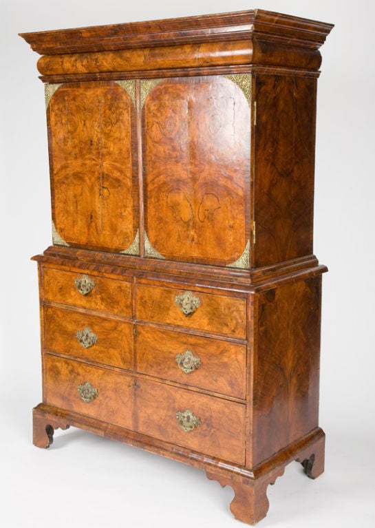 This fine and rare cabinet on chest from the Queen Anne period has a molded cornice fitted with a secret drawer, above two cupboard doors opening to reveal an interior fitted with drawers. The case below has two short and two long drawers, all