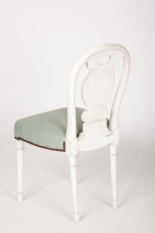 This set of four French side chairs have painted wooden frames with balloon form backs, derived from late eighteenth century French designs inspired by the balloon flights of the Montgolfier brothers.