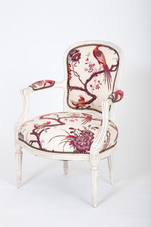 This French Louis XVI period open armchair, or fauteuil, is made of painted beechwood with carved neoclassical motifs.