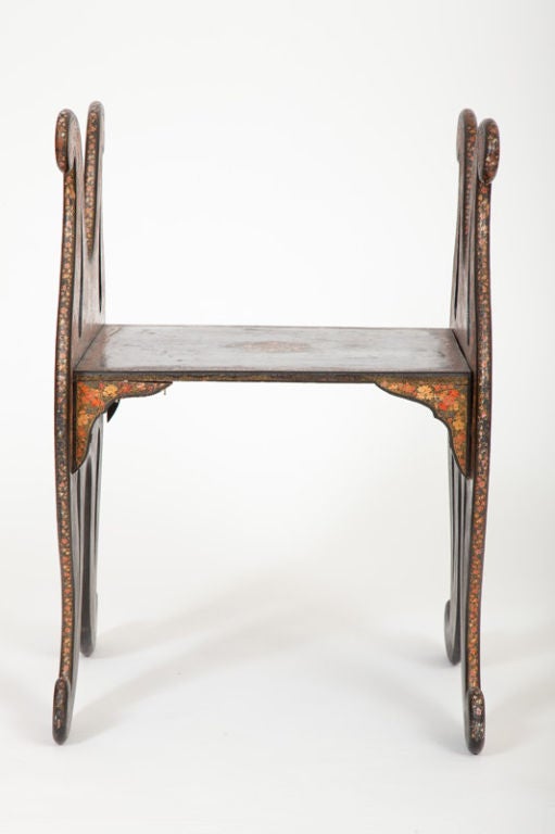 This stool with sinuously curving ends, forming arms and legs, supporting a central seating plank, was made in Srinagar, Kashmir in the second half of the nineteenth century. It is elaborately decorated with polychrome lacquer in the “Thousand