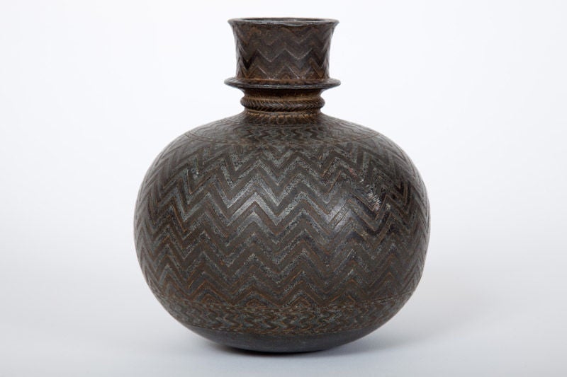 This fine Indian Bidriware vase, formerly a water pipe or hookah (huqqa) base, has a globular body decorated with a chevron pattern. This huqqa base would have originally been fitted with a long stem supporting a brazier and a pipe through which