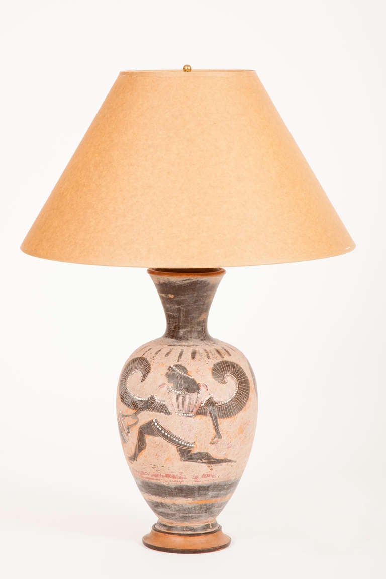 This Italian ceramic vase, now converted into a lamp, has a everted neck, a baluster shaped body and a molded foot and is decorated with winged figures and banded ornament. Probably made in Naples, this vase was directly inspired by Greek black