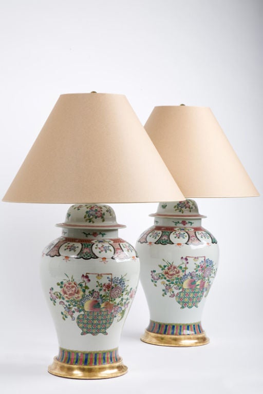 This large pair of Chinese baluster jars is decorated with polychrome enameled colors in the famille rose palette with baskets of flowers and fruit, now fitted as lamps with gilded wooden bases.