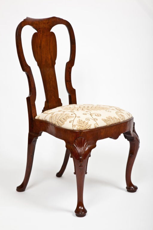 This fine English George II period walnut side chair has a curved splat back above a slip seat raised on cabriole front legs with shell motifs on the knees ending in pad feet.
Provenance: Cynthia Phipps, Old Westbury, New York.