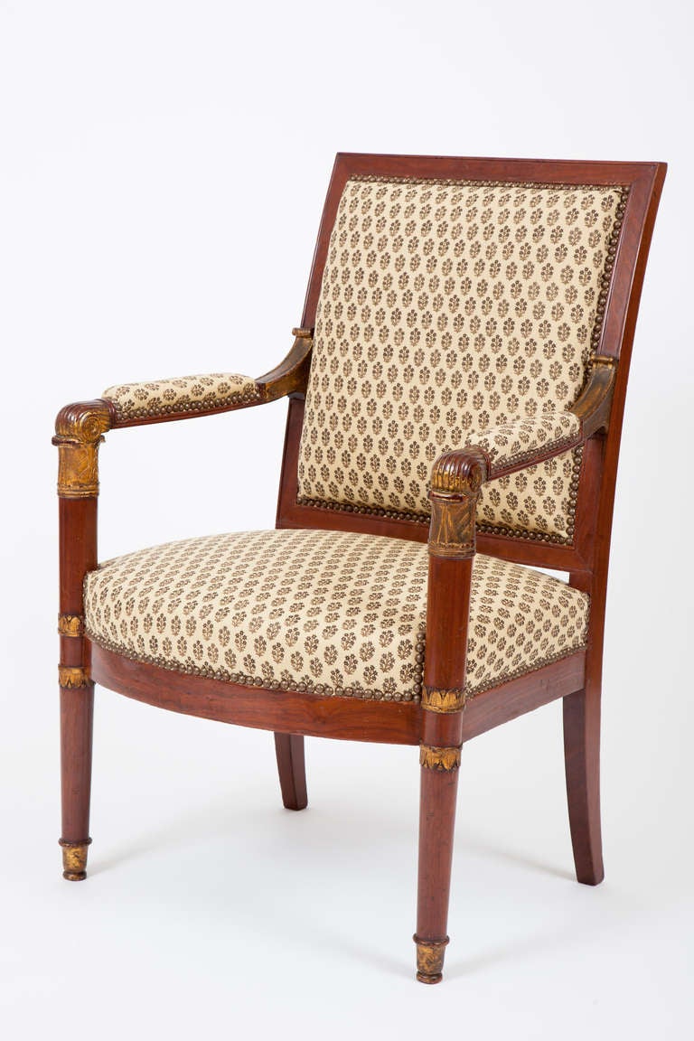 This French Armchair period armchair (fauteuil) is made of mahogany with parcel gilded details in the neoclassical taste.