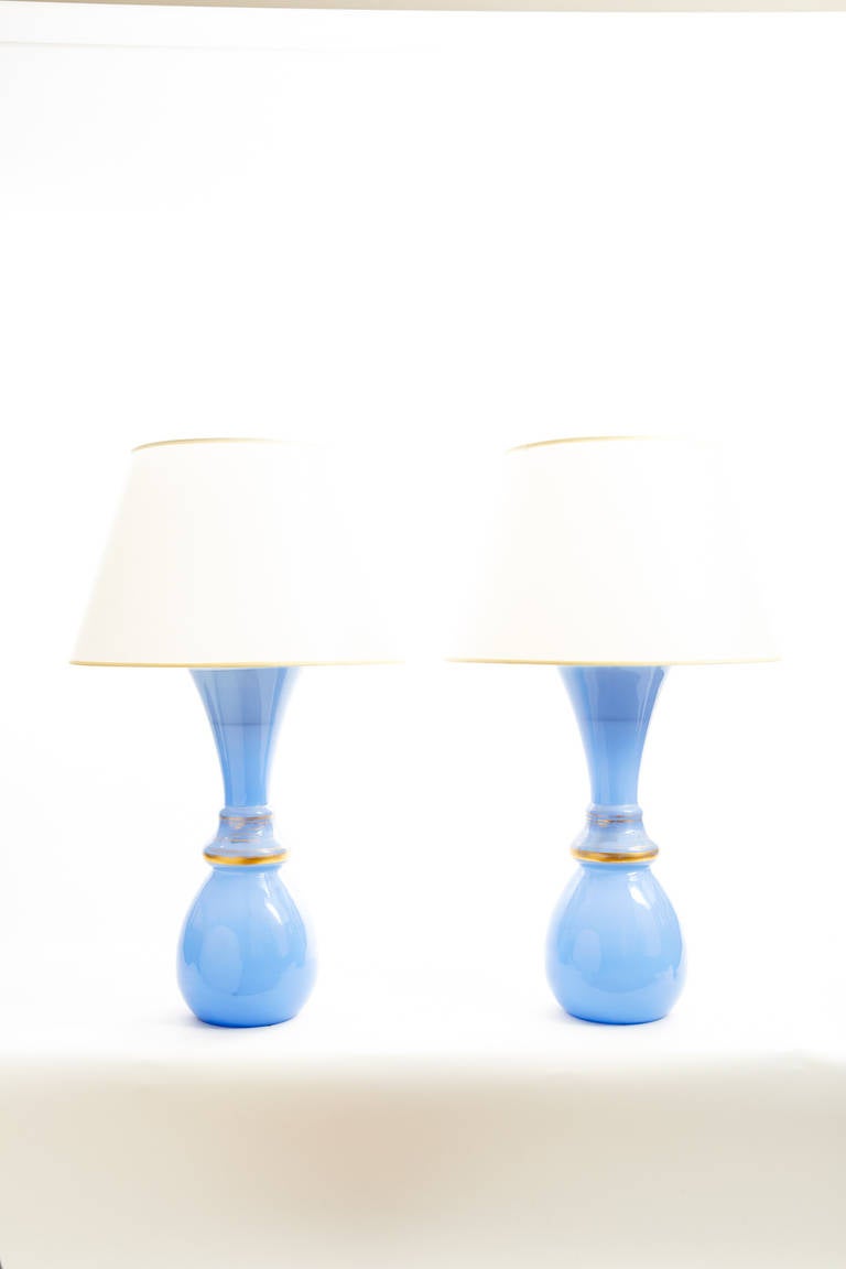 This large pair of French Napoleon III period lamps are made of Clare de Lune blue opaline glass vases with parcel gilded bands.