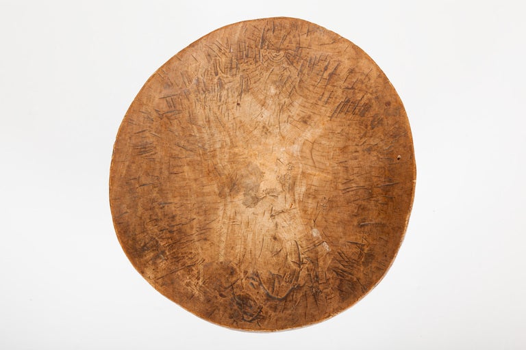 This Southern Ethiopian stool, made by the Oromo people in the mid twentieth century, was carved from one piece of wood with simple out-curved legs and a concave circular seat.