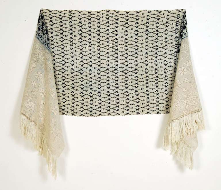 The macana of Cuenca is a feminine shawl of Spanish origin that is very similar to the Mexican rebozo. It is woven on a back strap loom with yarns that were previously patterned in a tie dye technique. The resulting pattern appears on the center of