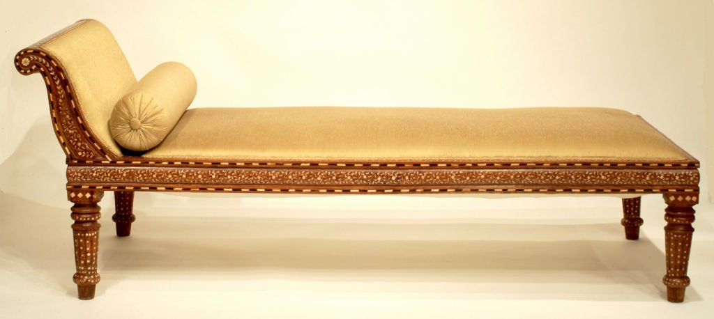 Chaise longue made of teakwood inlaid with bone in foliate design and upholstered with raw silk.
