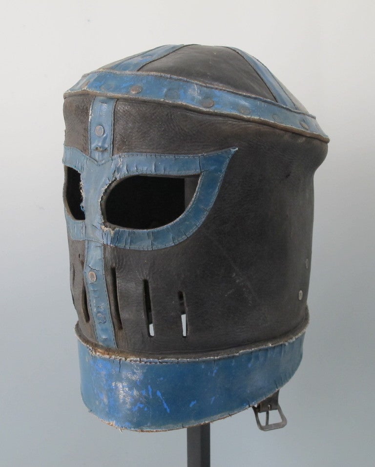 This rare wrestling mask came from the south side of Chicago.  Made of cut and riveted leather with blue dye adding to its medieval look.  A series of slots allows breathing and add to its ferocity.  Wrestling can be very theatrical.  There is a