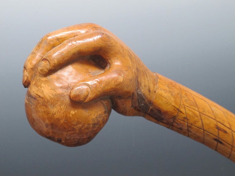 This old ball headed club is unusual in having a finely carved hand holding the ball or rock  Carved from one piece of hard wood the hand end has tree knots visible around the fingers which would give it additional strength.  The incised markings on