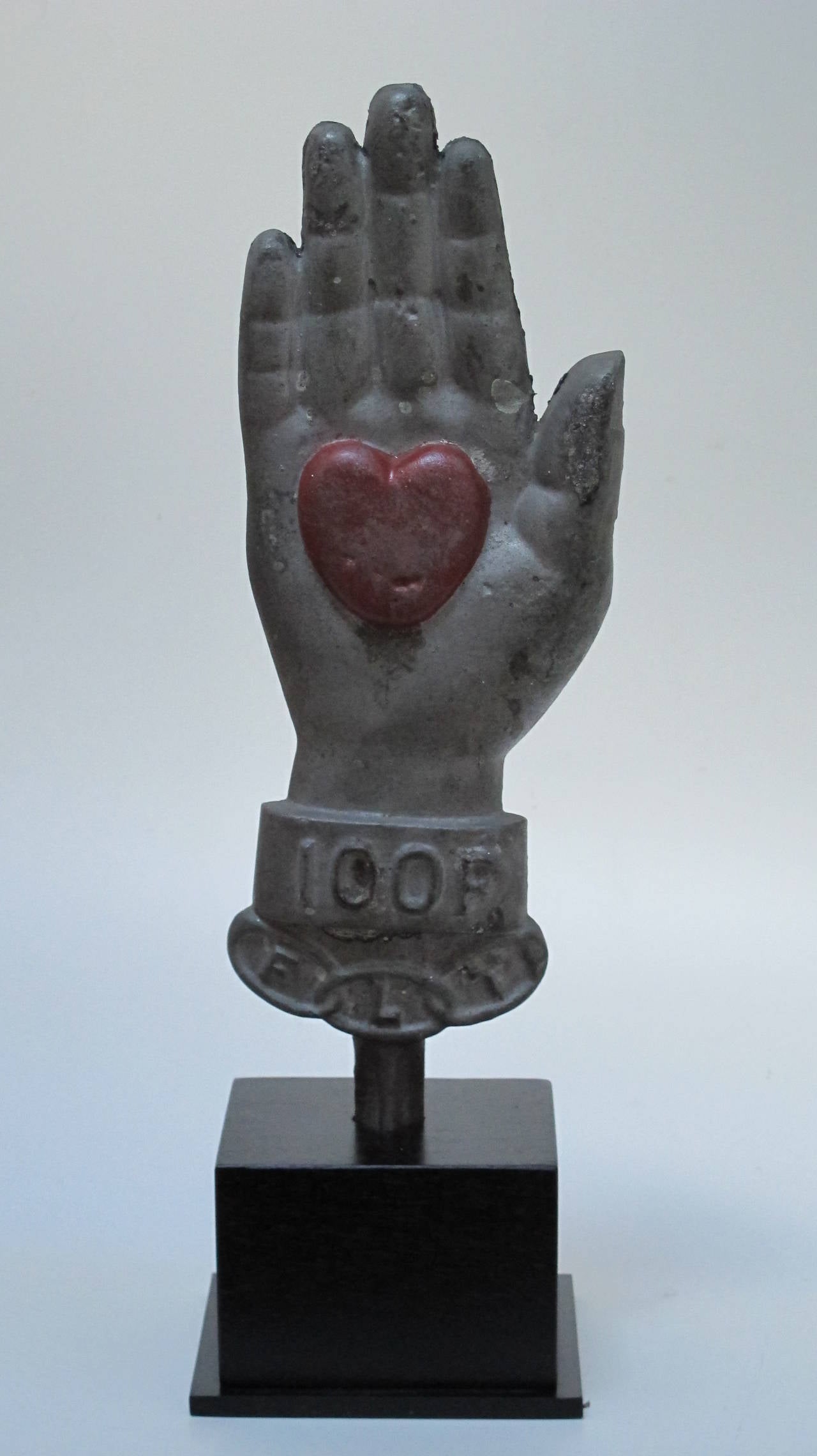 Painted cast iron symbol of Odd Fellows Lodge membership with three linked rings standing for friendship, loyalty, and trust. The heart in hand was a potent symbol for the members of the Lodge and community. The markers were originally made to honor
