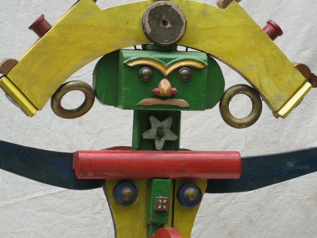 Winford B. Law was an eccentric self taught artist living near Buffalo, NY (deceased ). This sculpture is an assemblage of painted wood elements with added jewelry findings and small skull<br />
on one side. The figure has different faces on the