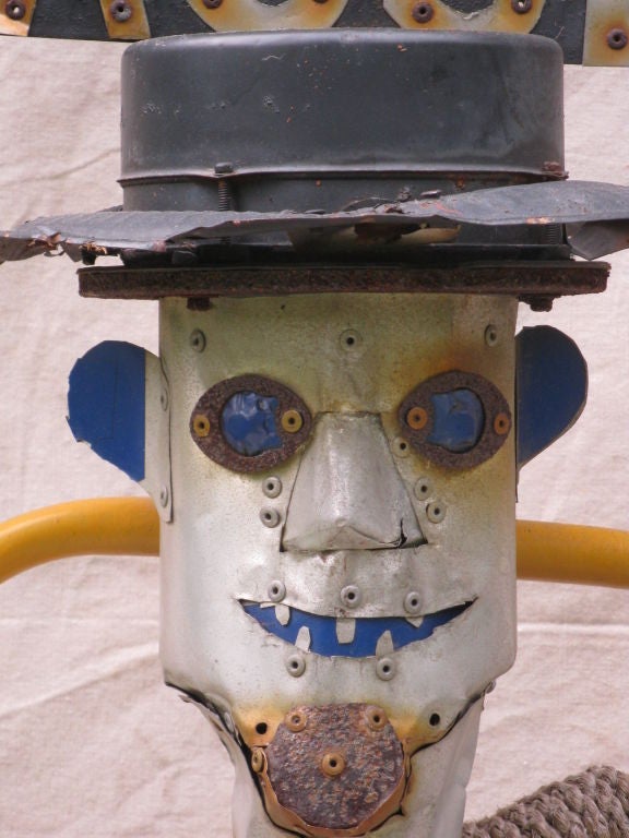 The Tin Man on cart was wheeled to the end of a driveway each evening by the unknown maker to protect his privacy. Folk Artists are compelled to create for many reasons. Note the rope around the neck and the reflective blue eyes to scare away