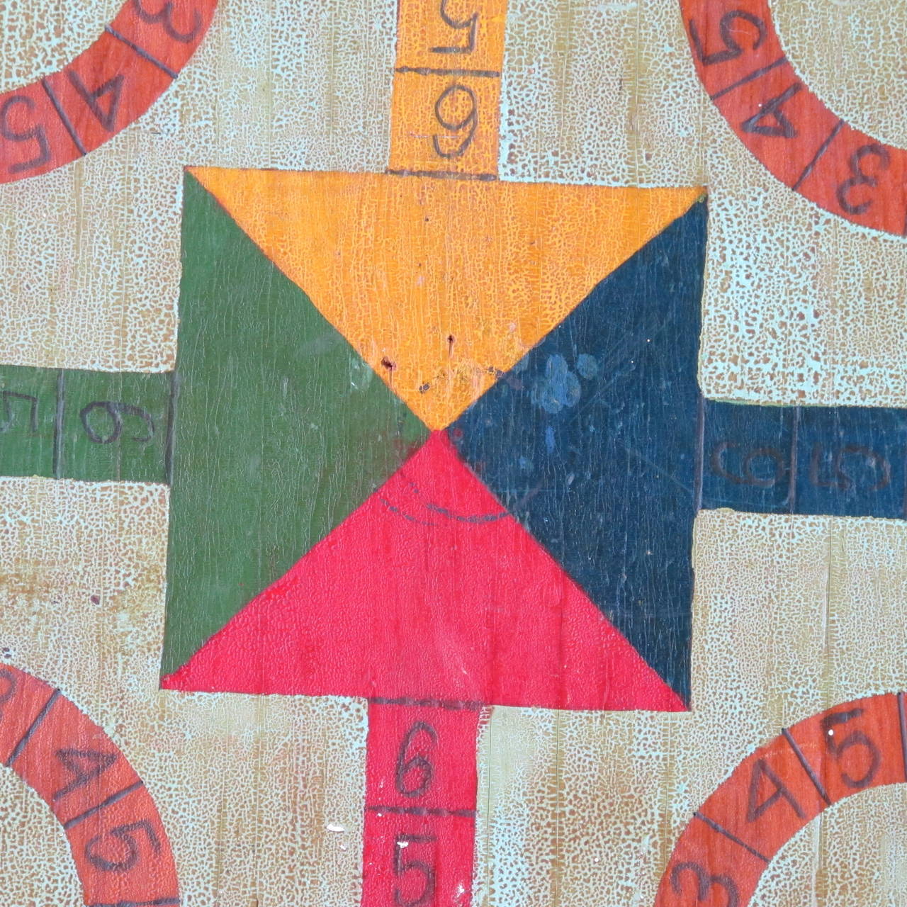 Gameboard with primary colors on wood panel. The game has the starter colors in the corners and a numbered trail around the board.