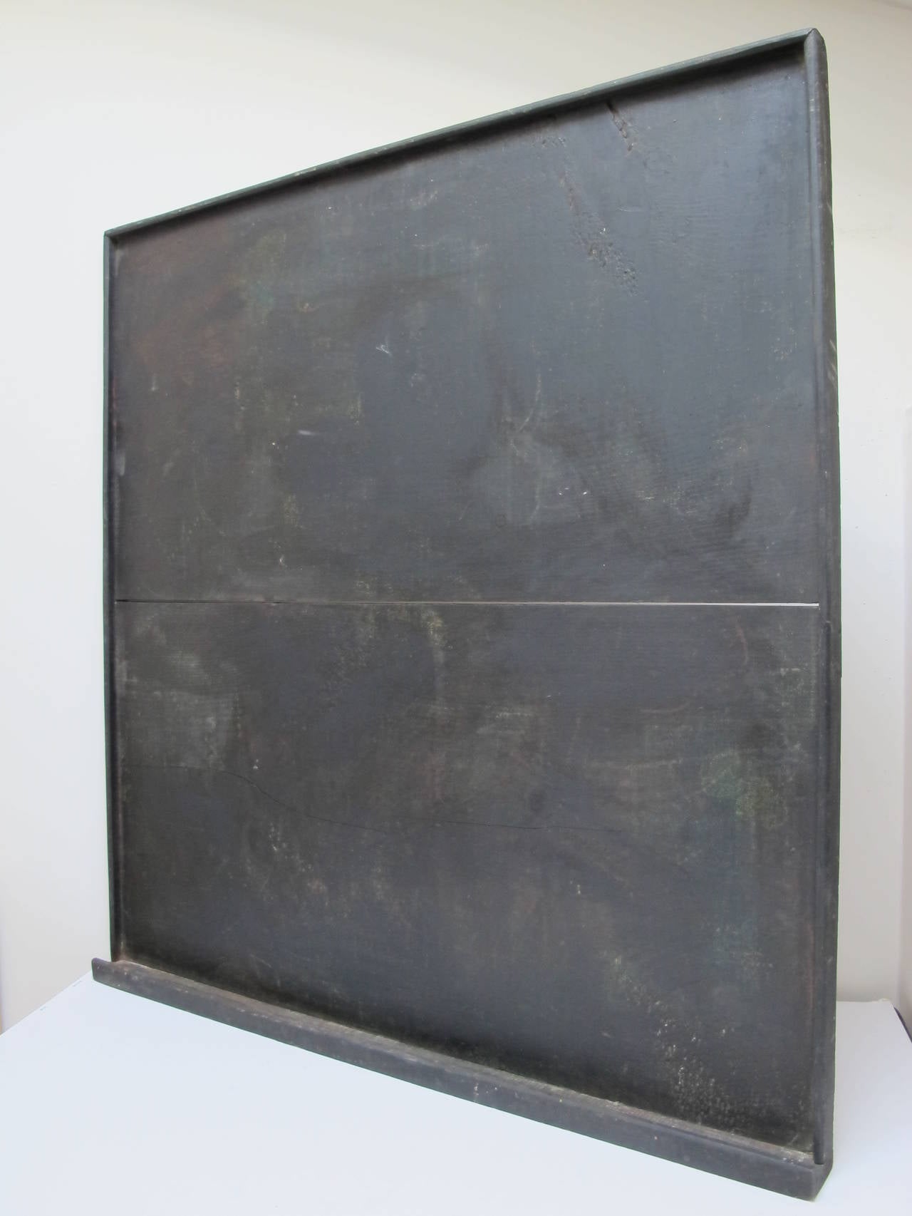 Well made wooden blackboard with bottom wood tray for chalk and erasers and  edge molding. The flat  black board has a slight dark greenish tone to the painted surface that consists of 2 wide boards.
