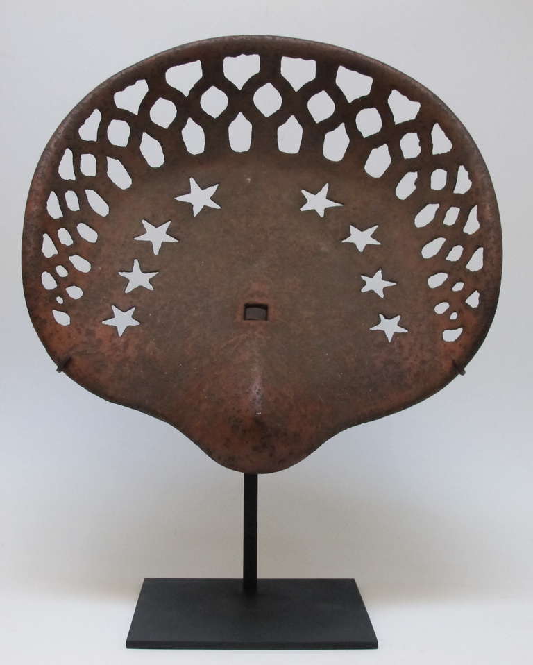 Beautifully designed graphic farm tractor or implement seat with cutout stars.
Not only were these seats works of art but they were designed for comfort.
This is among the best cast iron farm seat designs. Mounted on a custom metal stand. ht on