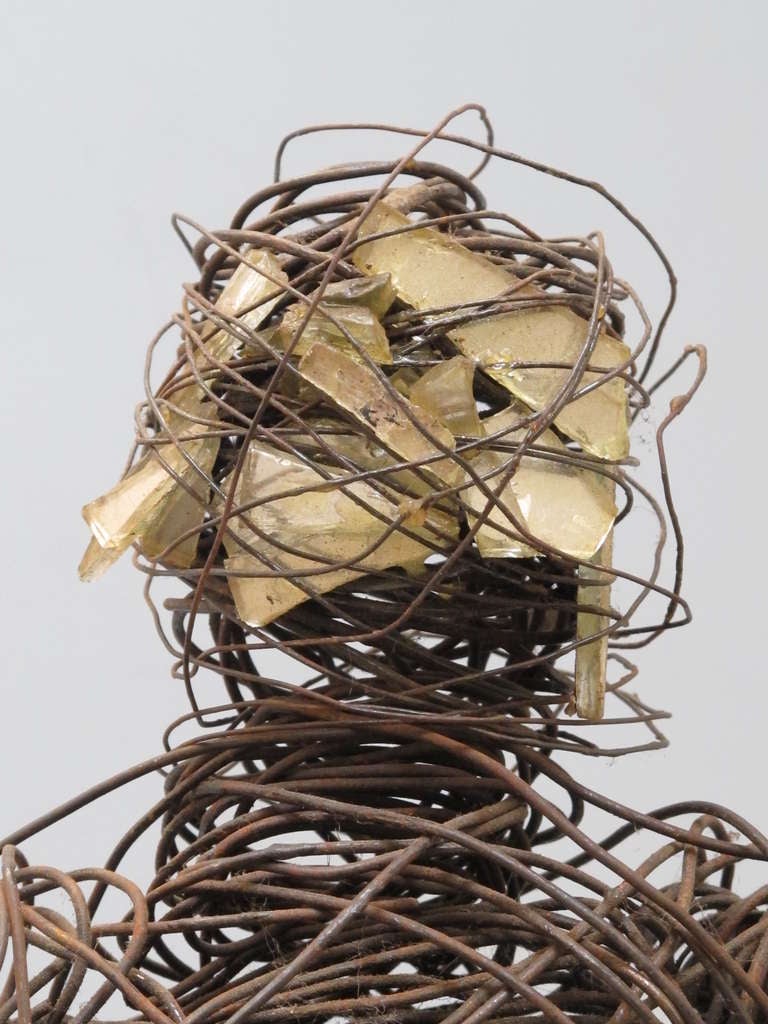 Powerful coiled wire figure with face of shards of broken mirror. Tightly coiled and animated, the volumes of the body end in detailed wire hands. The pieces of old mirror animates the figure and gives it a surreal mystery.unlike any other folk art