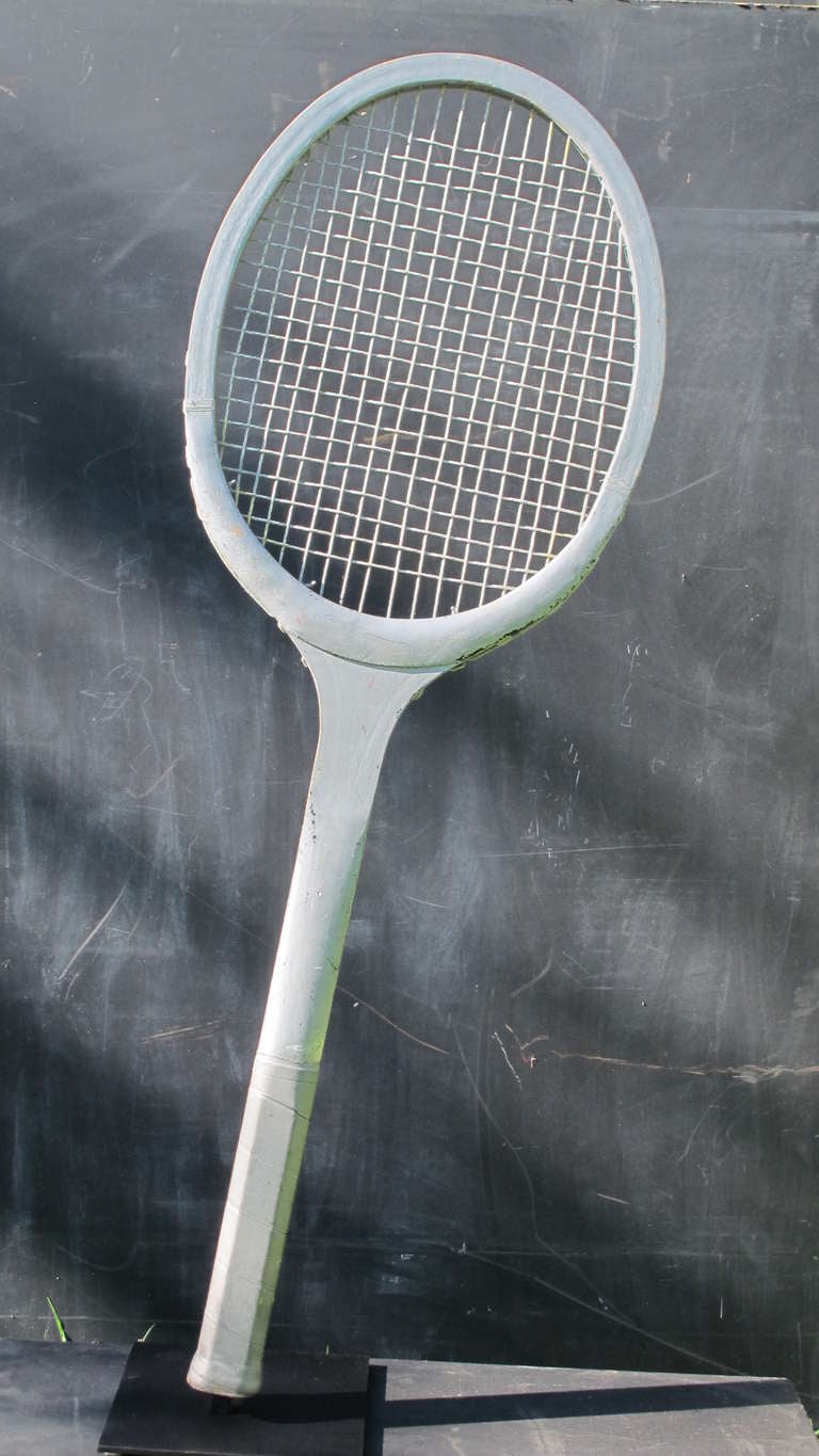 Oversized tennis racquet made for Tennis shops for promotion of Bjorn Borg in the 1970s.  Under the silver paint are colors and markings associated with B.Borg.  Mounted on metal base at a dramatic angle.