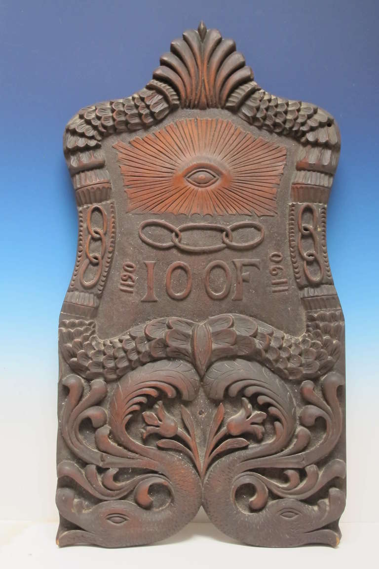 Carved wood shaped panel with symbols of the fraternal Order of Odd Fellows.
One of a kind carving with multiple linked rings, the All Seeing Eye and feathered duck heads. Marked on back B. Costantin, Pittsburgh.