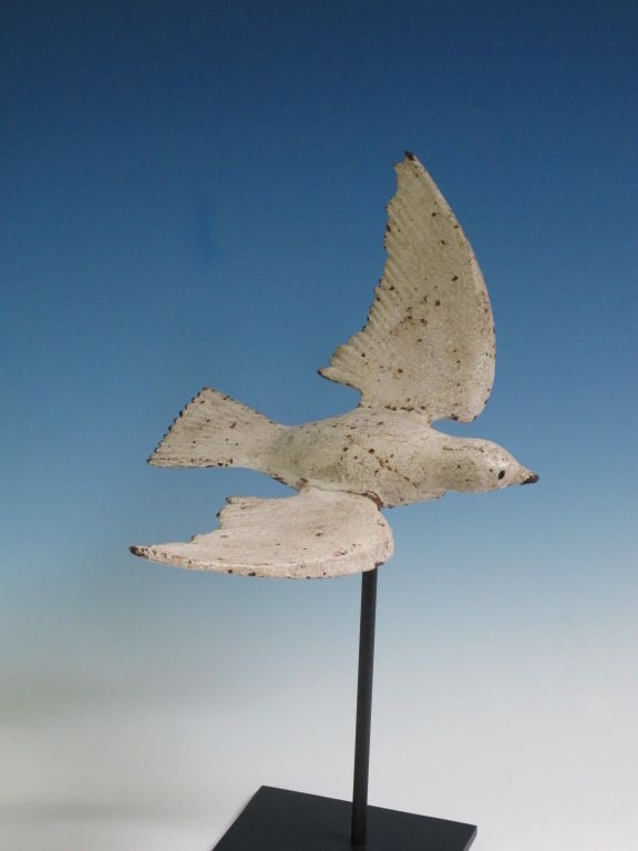 Garden sculpture of a bird in flight with old white paint. Iron peg in underside is used to float it over a metal base.   Ohio