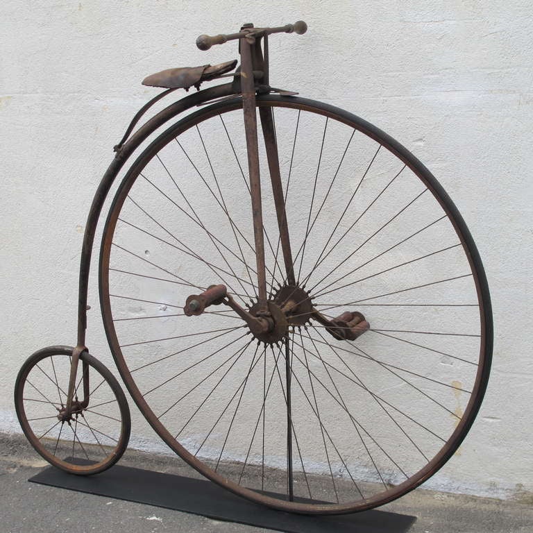 Early American bicycle in wonderful working condition. The iron frame retains some of its original gold pin striping decoration.
Turned wood hand grips, leather seat covering, and rubber tires and peddle rests. Mounted to be freestanding as a