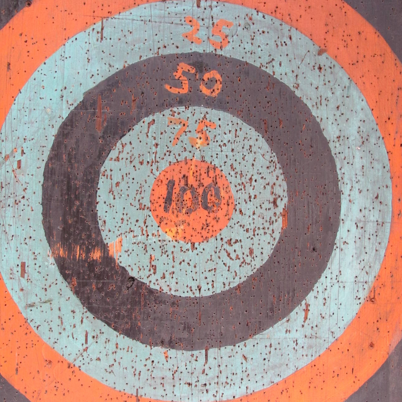 Graphic dartboard with well painted target. It shows a history of use yet it is a survivor. The wood may have had an earlier life as an old school writing board.