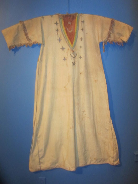 Dress of muslin, thread & sinew,with native pigments worn in the native American religion that flourished at the end of the 19th century and culminated in the massacre at Wounded Knee in 1890. The dress like form is decorated with celestial symbols