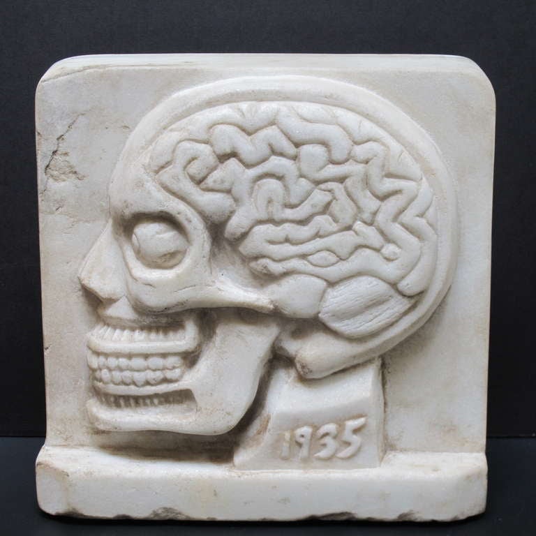 One side of the free standing marble relief shows an intact skull. The other side shows the skull with interior including the brain as a cutaway view.Initialed HD on one side and 1935 on the other side. This yet to be identified artist believed to