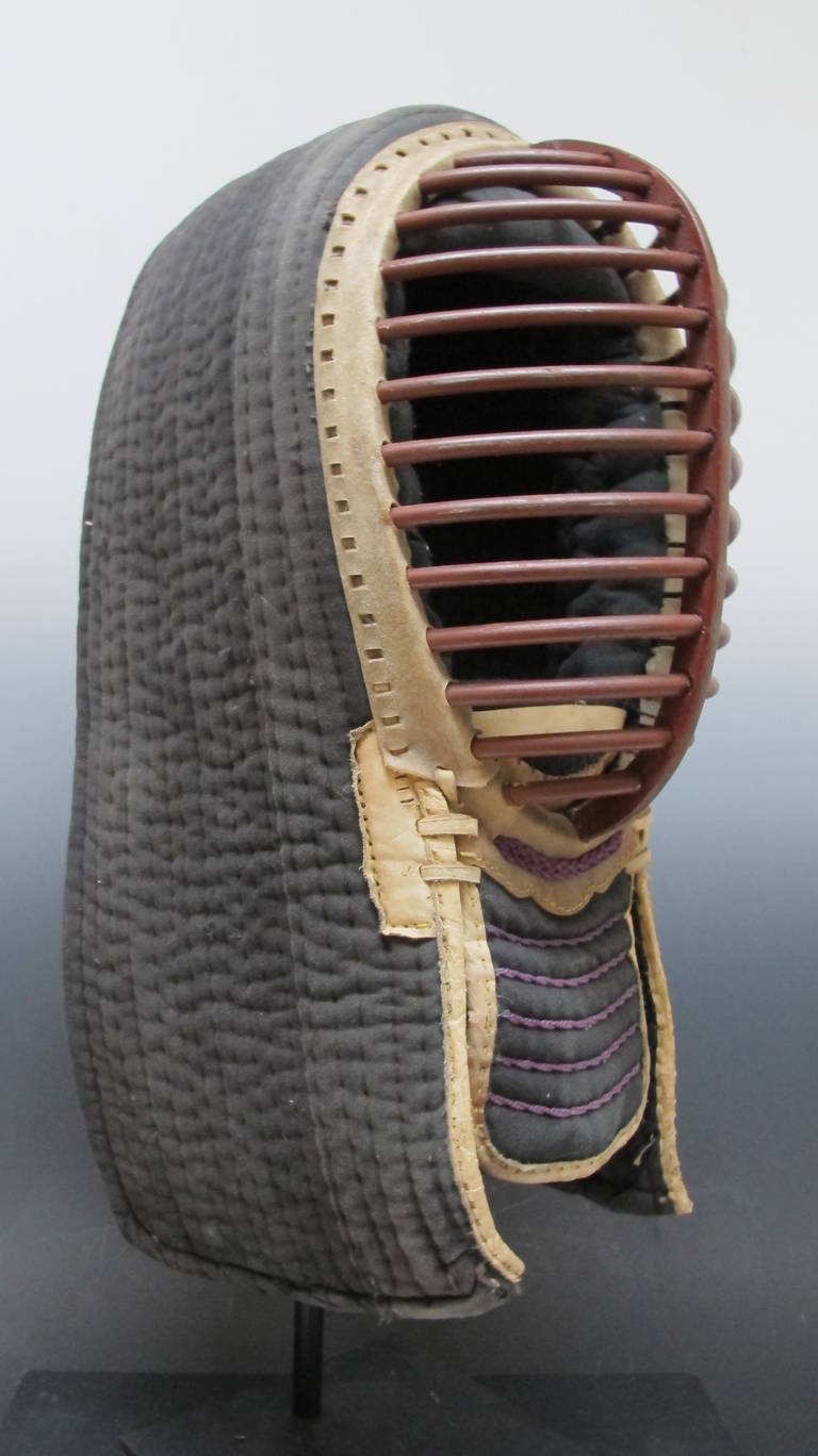 Japanese Kendo masks are finely crafted of iron ribbed face guard and quilted cotton cloth head protection. The martial art of Kendo is fought with wooden batons. This helmet is more contemporary than others I have had yet it is in the best