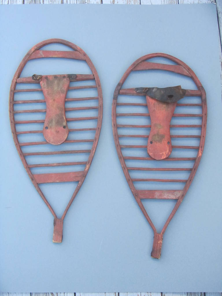 Rare pair of snowshoes made of bentwood frame and pegged dowel crosspieces
and inset flat wood. There are shoe shaped flat wood pieces to tie the boots onto that are joined at the front. A wonderful old surface with reddish brown paint. These were