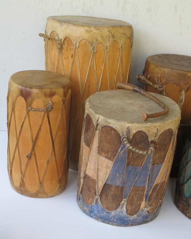 Group of nine drums with hide covers stretched over carved wood forms. Some of the drums are paint decorated. Makes a wonderful sculptural grouping. After dinner have your own drum circle with dancing. Each drum has its own distinctive sound. Two