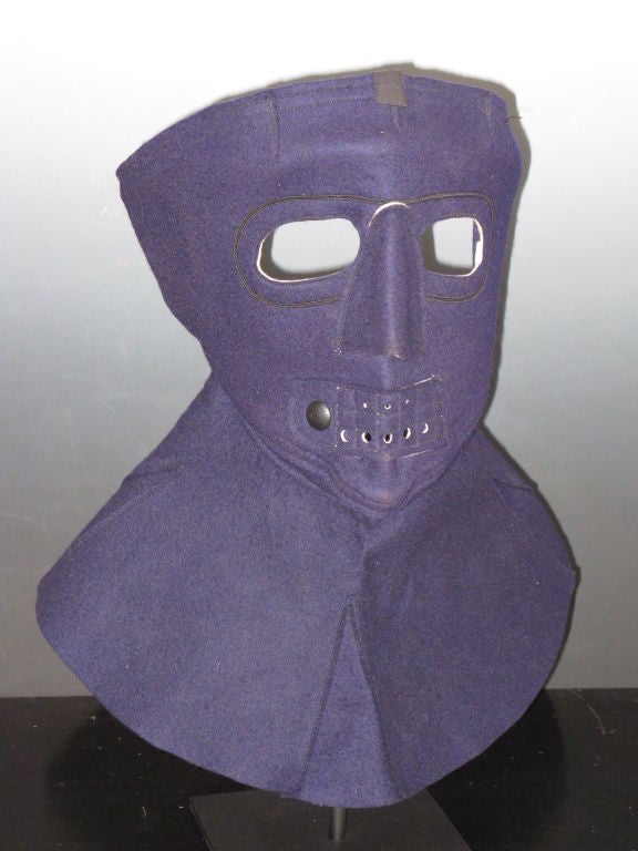 Blue felt cloth mask for cold protection for military aviation. Probably from the Korean War period.   Mounted on metal base height on base 17 inches. A related mask was exhibited at MOMA
in the exhibition 