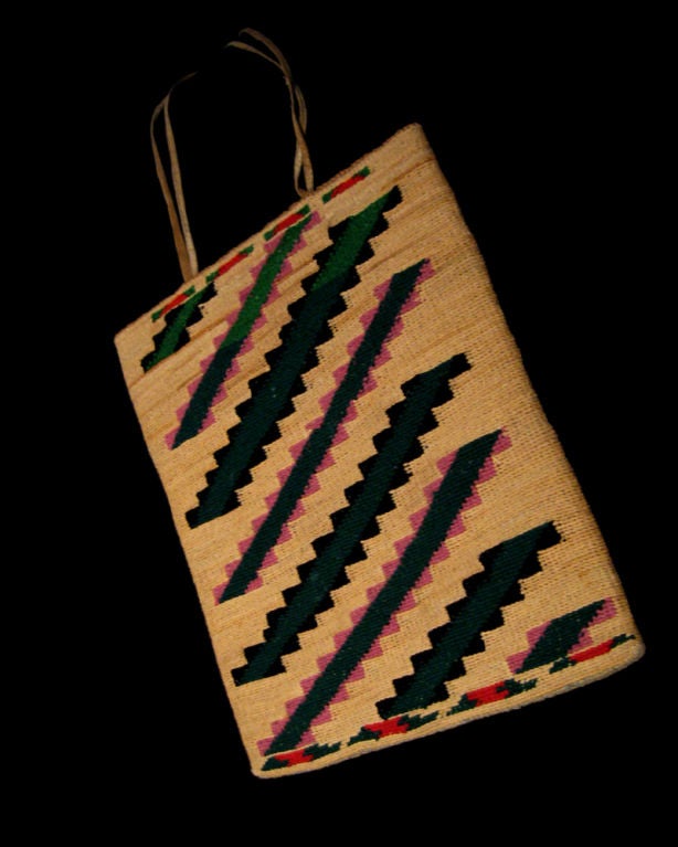 Native American carry bag made of woven corn husks with graphic traditional designs to both sides. Leather carry strap for shoulder.