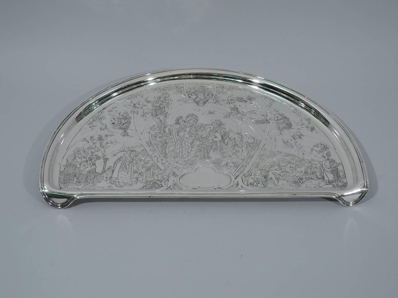 Sterling silver highchair tray. Made by William B. Kerr in Newark, ca. 1910. Lunette-form with acid-etched scenes from Mother Goose, including Red Riding Hood, Humpty Dumpty, and Little Bo Peep. In center frame sits the old dame herself surrounded