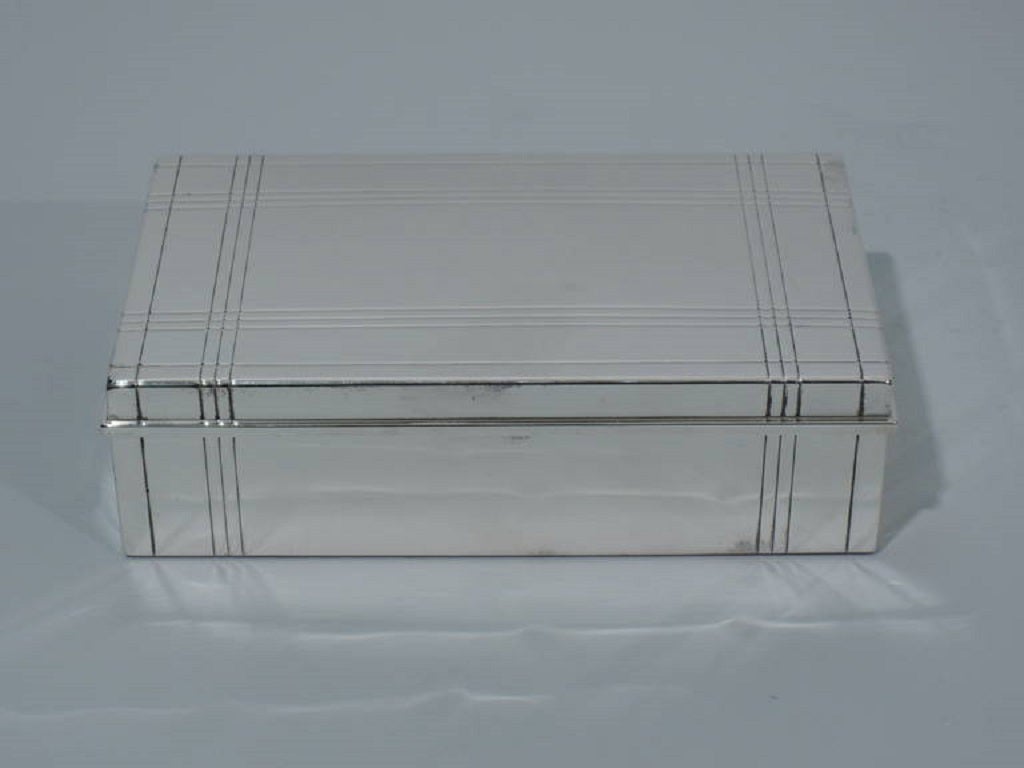 Sterling silver desk box. Made by Tiffany & Co. in New York, ca. 1945. Rectangular with straight sides. Cover is hinged with molded rim. Chased grid pattern that runs continuously on sides and cover. Linear and rational. Box interior cedar lined.