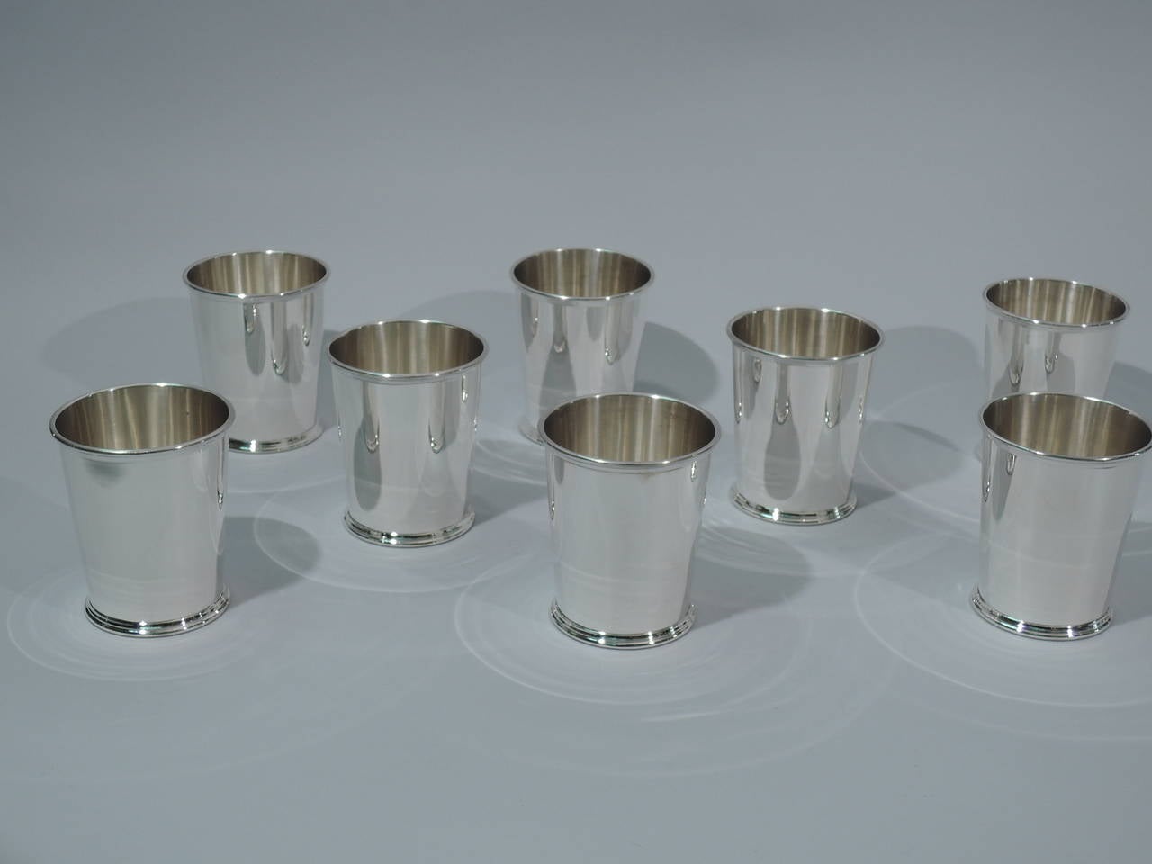 Set of eight sterling silver mint juleps. Made by S. Kirk & Sons in Baltimore, ca 1950. Each: straight and tapering sides, reeded rim, and spread and reeded foot. Hallmarked. Excellent condition. 

Dimensions: H 3 3/4 x D 3 1/4 in. Total weight: