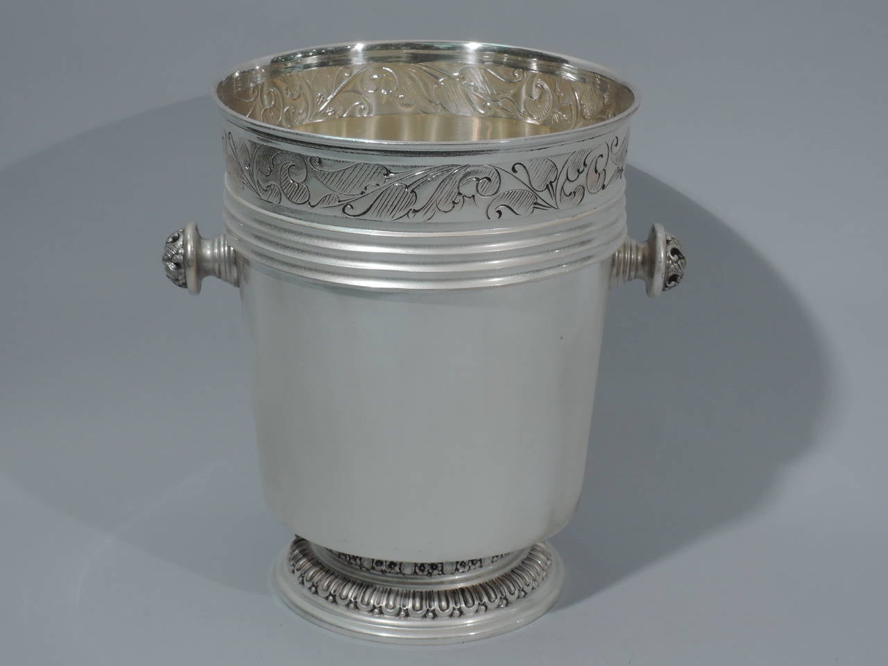 Modern classical wine cooler in 800 silver. Made by Mario Poli in Milan, ca. 1950. Straight and tapering sides. At top is engraved and stylized floral border above ribbed bands. Horizontal side handles in form of stepped cone mounted to dome with