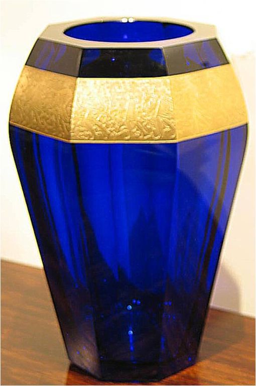 C19954   <br />
    An American vase c. 1920 signed MOSER. Cobalt blue blown glass with sliced cut panel body and 22 K gold panel w/ classical figures in relief.<br />
11.50 in. H x 8 in. Dia