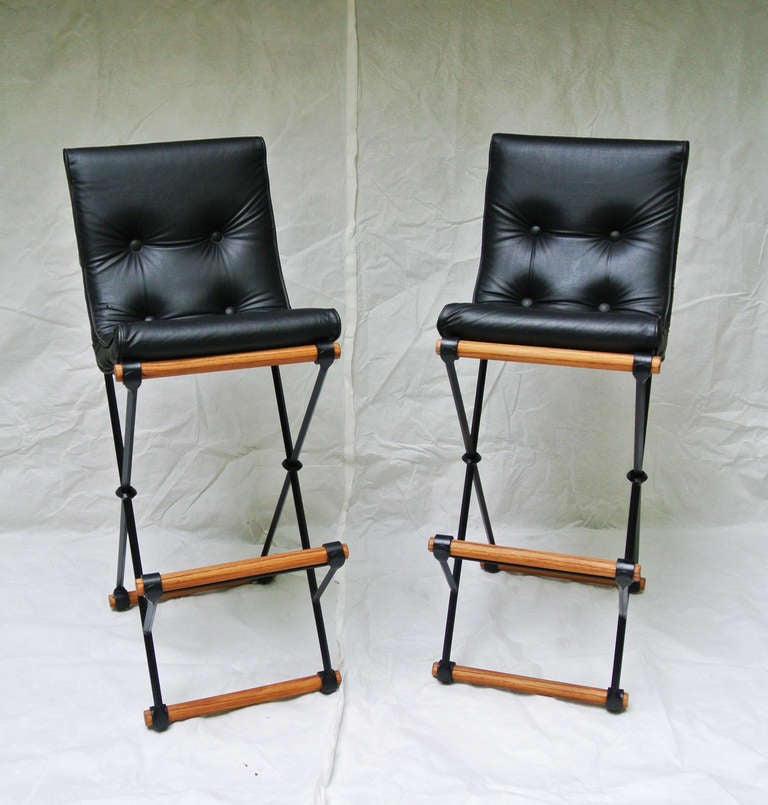 A classic pair of wrought iron and oak X-frame high back bar stools   by Californian Cleo Baldon for Terra Furniture. American, circa 1960's. This design was created at the request of Dean Martin for a high back bar stool for his home in the