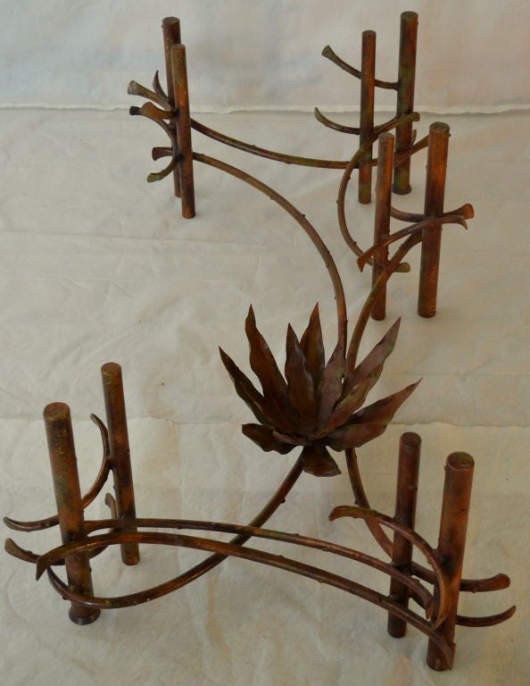 A complex table base of pinched copper tubes ribboned between ten vertical capped copper supports in the style of Silas Seandel. 
There is a variety of bronze and vegetative colored patinas. The various colors have been brushed in interesting