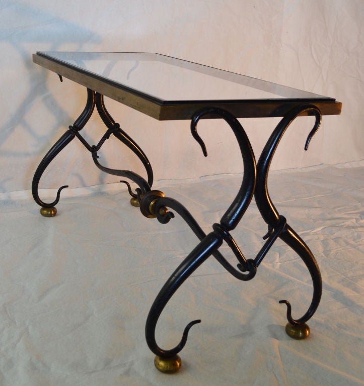 Exquisite coffee table by Arturo Pani from the late 1940s. The artistically designed base is constructed and composed of serpentine arabesque jet black lacquered wrought iron separated by bronze orbs. 

A perfectly scaled table of distinct design