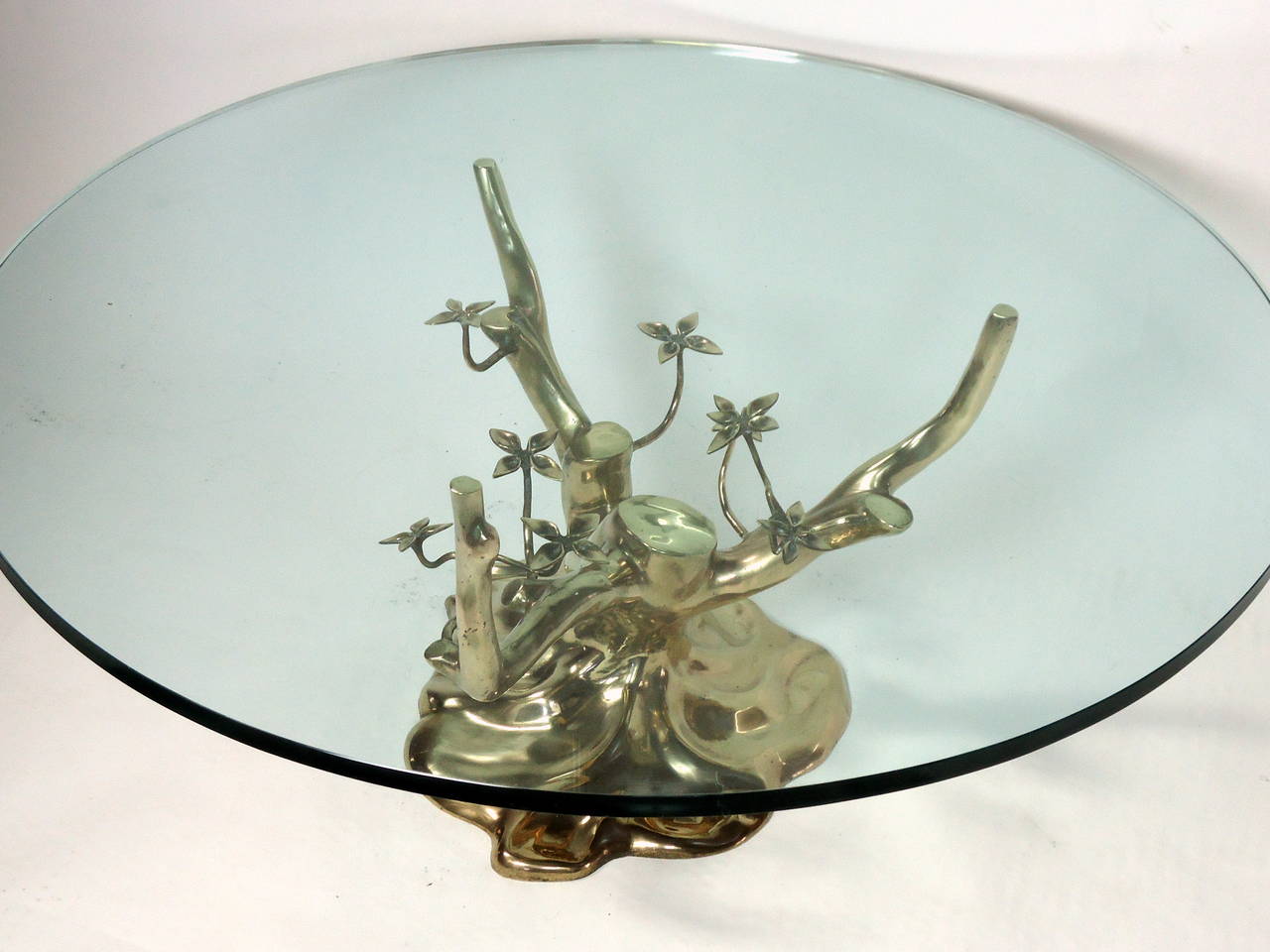 Elegant glass top polished bronze cocktail table in the style of Willy Daro and Jacques Duval-Brasseur. 
An unusual Bonzai tree form with articulated leaves makes this a very interesting table.
The table is in excellent vintage condition with its