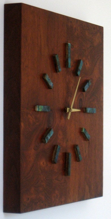 Classic 1960's battery powered wall clock from Harris Strong with opposed book-matched veneers of black walnut and turquoise ceramic tile markers.  .