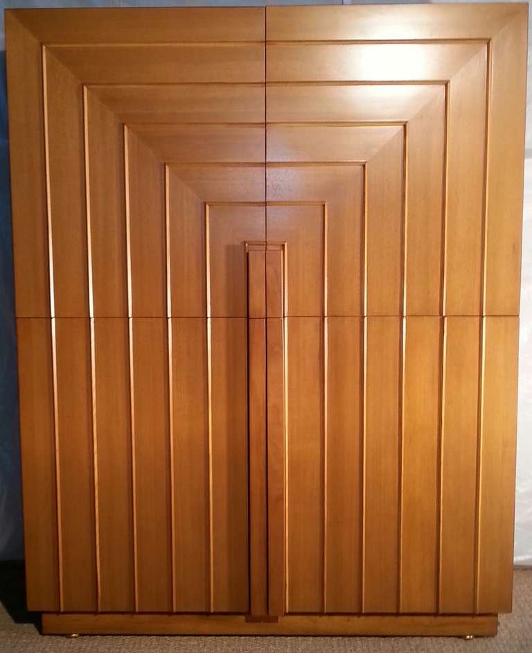 A large walnut four-door Classic armoire with nine drawers below capped with a variety of shelving designed by T. H. Robsjohn-Gibbings for Widdicomb. 

A great storage piece. 

This armoire has been professionally refinished and is in excellent