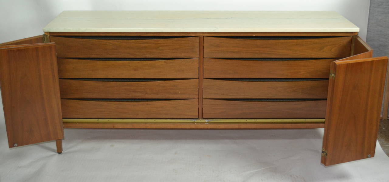 Paul McCobb eight-drawer walnut dresser is part of McCobb's Irwin line manufactured by Calvin Furniture of Grand Rapids during the 1950s.
The cabinet has 2 folding doors of three panels each that conceal eight ample drawers. The six panels are