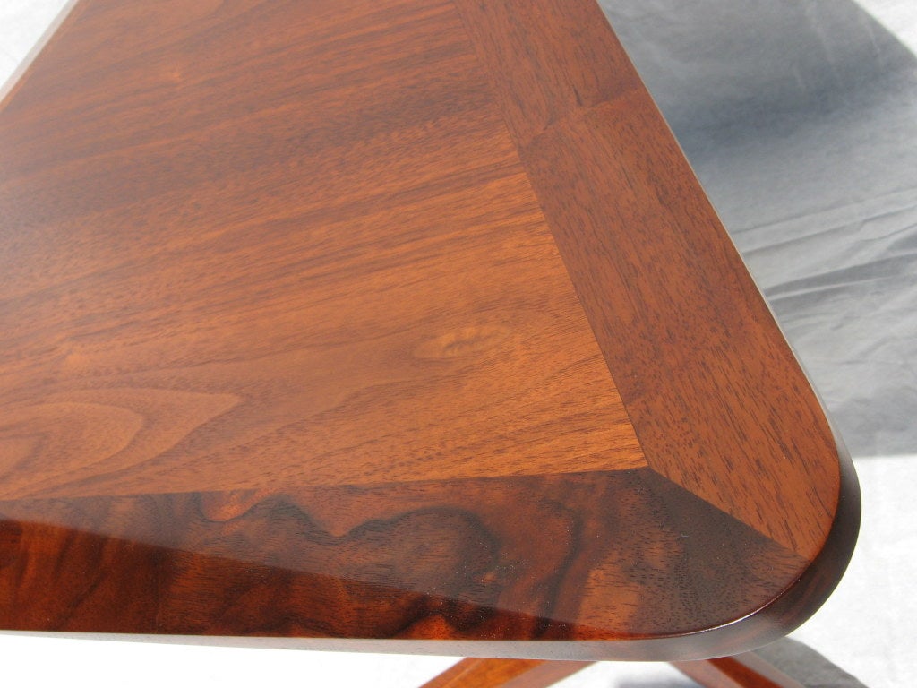 The table is built with triangulated components throughout. Beautifully made possibly Drexel Heritage, the top is a triangle of walnut veneer plywood cased within a border of shaped black walnut. The triangulated support is held vertically between