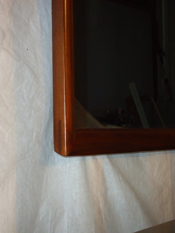 Schlichter, eleganter Spiegel, entworfen von Merton Gershun für seine Linie Dania für American of Martinsville. Rosenholzfarbener Nussbaum. Ein zusätzliches Detail ist die Verwendung einer großen Fingerverbindung an jeder Ecke.

Der Spiegel wurde