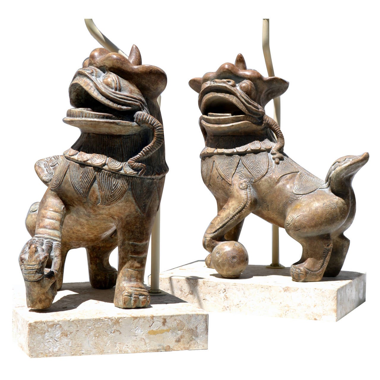 An unusual pair of Foo dog table lamps mounted on coral stone bases in the style of Michael Taylor. 
The subtle glazed surfaces of the ceramic dogs are in stark contrast to the texture of the fossil stone bases.
The lamps are substantial the dogs