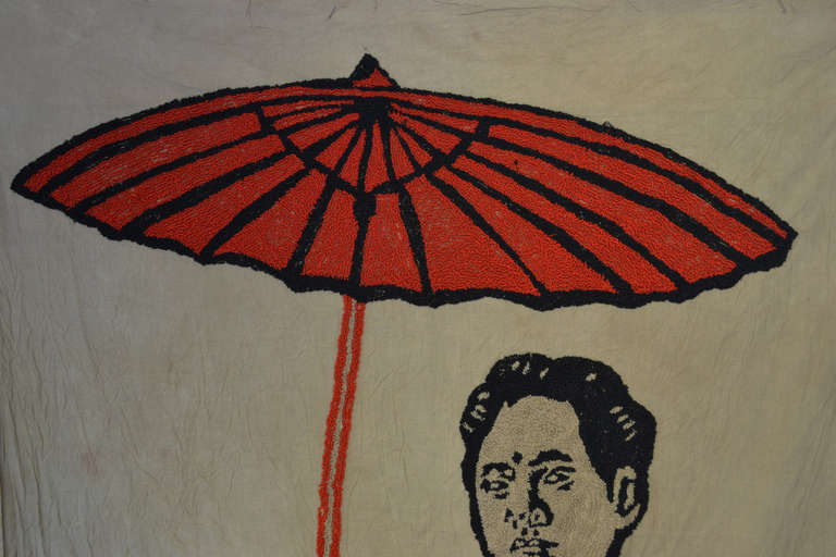 A graphically bold, lifesize embroidered textile depicting Moa Zedong grasping a symbolic red umbrella and shoulder satchel. The banner was created as a potent visual tool in announcing chairman Mao's visit along a parade route to a specified